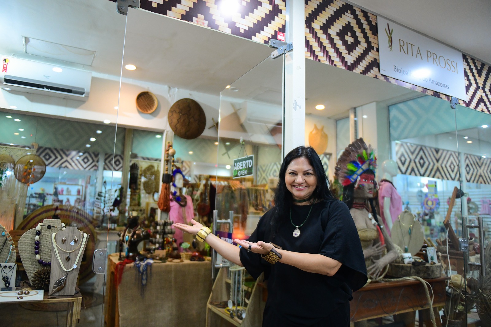 Última reportagem da série em homenagem ao mês da mulher, intitulada “Turismanas”, mostra a trajetória de Rita Prossi Mãos que criam, arte que transforma a vida de mulheres. O Governo do Amazonas e a Empresa Estadual do Turismo (Amazonastur) apresentam, nesta última reportagem em homenagem ao mês da mulher, intitulada “Turismanas”, a história da artesã Rita Brasil, mais conhecida como Rita Prossi. A amazonense se junta a mulheres que encantam os turistas com o artesanato local. Da comunidade do Paraná da Eva, em Itacoatiara (a 176 quilômetros de Manaus), Rita Brasil, seu nome de batismo, nasceu artista e viu nas natureza e nas habilidades manuais de corte e costura da mãe, as grandes inspirações para desenvolver a marca de biojóias da Amazônia “Rita Prossi”. “Ela criava nossos modelos de roupa conforme o nosso corpo e a nossa personalidade, isso foi uma grande influência para mim. Além disso ela contava as histórias das lendas amazônicas. Ela é a minha grande inspiração como mulher”, relembrou a artesã. As mulheres são maioria no artesanato amazonense. Dos 6.268 artesãos cadastrados no sistema da Carteira Nacional do Artesão, 75% são mulheres, conforme dados da Secretaria Executiva do Trabalho Empreendedorismo (Setemp). Para Rita, o artesanato é um pequeno pedaço da experiência no Amazonas que os turistas fazem questão de levar. “O artesanato é um peça primordial no turismo do Amazonas, porque quando o europeu ou o americano, ou de qualquer outra nacionalidade, vem ao Brasil ou ao Amazonas ele quer levar alguma coisa daqui, uma simbologia amazônica, um souvenir. Ele quer levar algo da nossa região”, pontuou. As mulheres que trabalham com artesanato sustentam uma grande cadeia produtiva, segundo Rita. Somente para a marca da artesã, direta e indiretamente, aproximadamente 100 pessoas estão envolvidas na produção. “Eu acredito que o artesanato é como uma grande vitrine para o mundo através do turismo. Ele impacta várias famílias, é responsável pela sustentabilidade de vários povos indígenas, ribeirinhas e da capital também”, explicou. Reconhecimento Com o seu trabalho conhecido por turistas do mundo todo, Rita já teve a oportunidade de entregar peças para o atual rei da Inglaterra, Carlos III, a rainha consorte Camilla Parker Bowles, além da rainha Silvia, da Suécia. “Tivemos também a oportunidade das nossas peças serem levadas para sete países importantes, como as que foram para o príncipe de Mônaco (Alberto II), para o governador da Califórnia na época, Arnold Schwarzenegger, Papa Bento XVI, tenho uma peça em exposição no Museu do Índio (Museu Nacional do Índio Americano – George Gustav Heye Center em Nova York) , em Nova York, levada em 2010”, relembrou orgulhosa. Turismanas Neste mês da mulher, a série de quatro reportagens, “Turismanas”, homenageou mulheres que promovem direta e indiretamente o turismo amazonense. O projeto também foi acompanhado por publicações nas redes sociais que contaram a trajetória e o envolvimento das personagens.