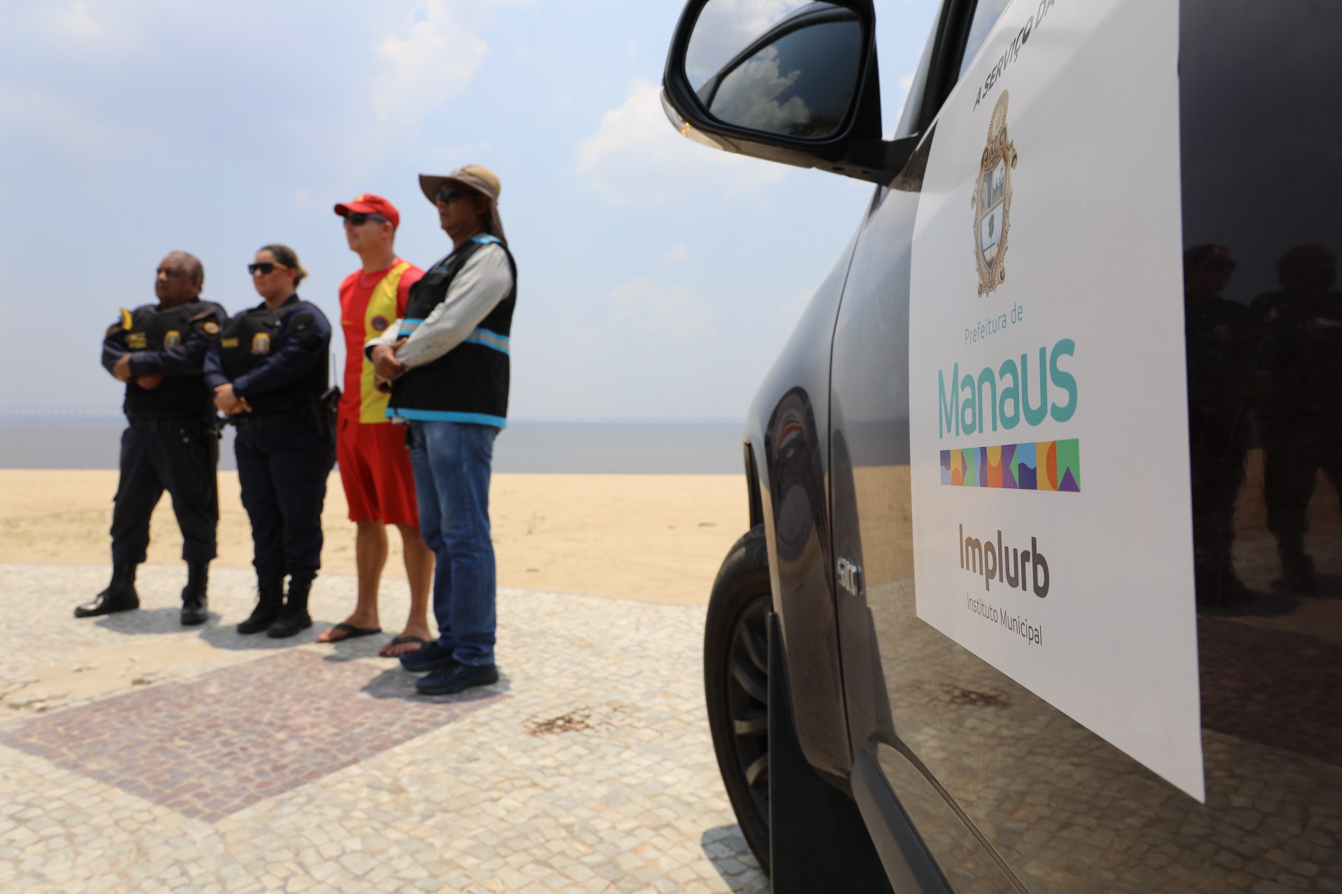 Descumprindo interdição, grupo de banhistas é orientado a sair da praia da Ponta Negra na extrema vazante do rio