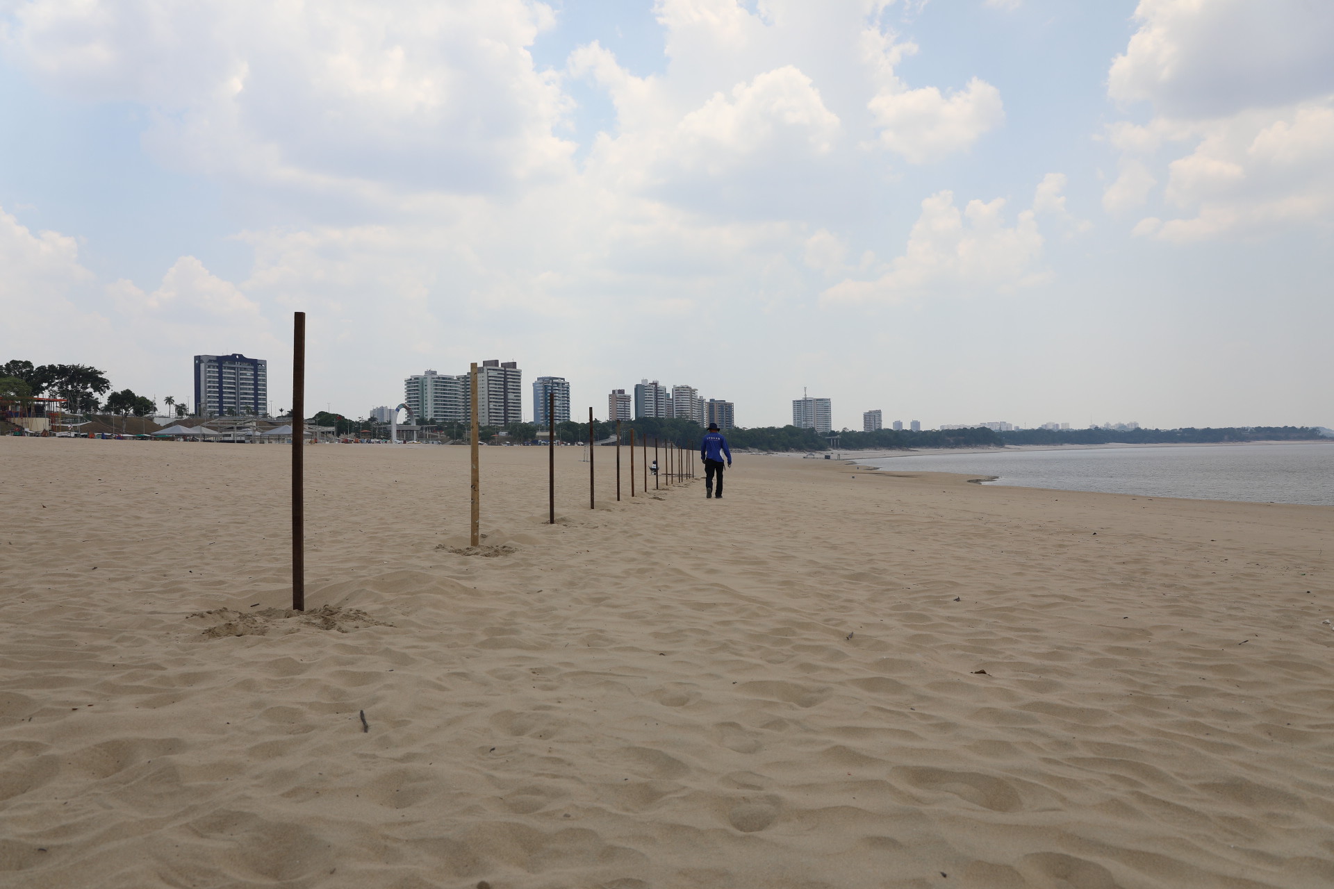 Descumprindo interdição, grupo de banhistas é orientado a sair da praia da Ponta Negra na extrema vazante do rio