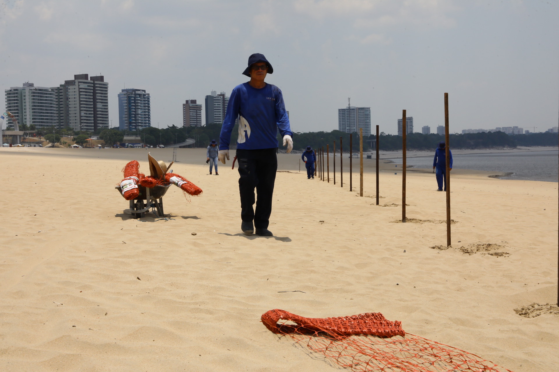 Descumprindo interdição, grupo de banhistas é orientado a sair da praia da Ponta Negra na extrema vazante do rio